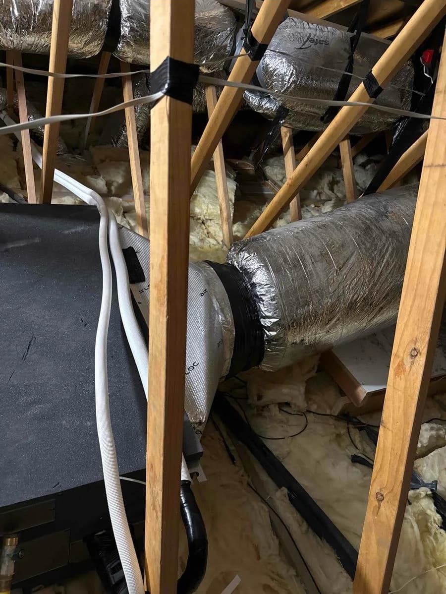 Insulated ductwork connected to a whole-home air-conditioning system in a roof space
