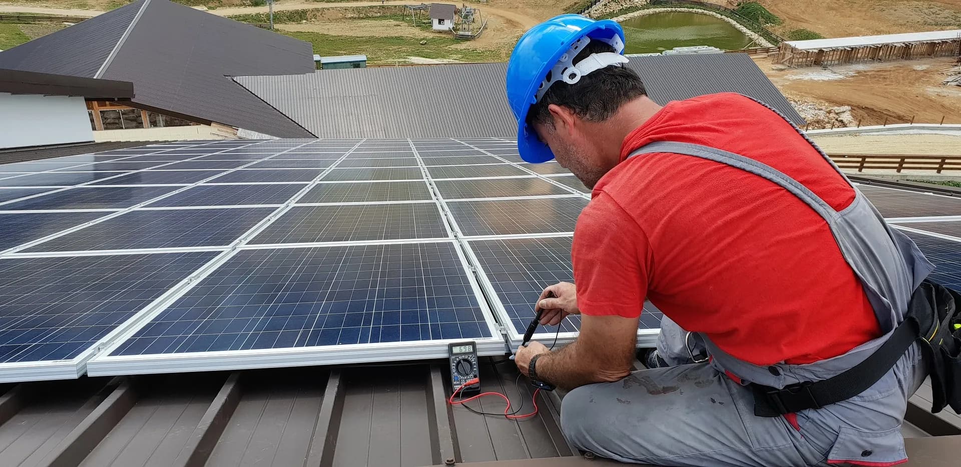 Solar technician inspecting rooftop panels during maintenance